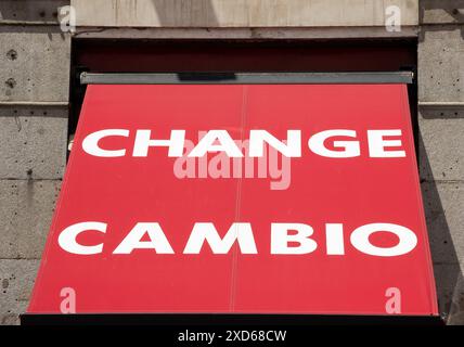 Red awning with the words 'change' and 'cambio' written in white letters above the door of a money exchange office in Madrid, Spain Stock Photo