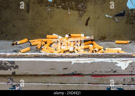 Stubbed-out filter cigarettes left in pile on old window ledge - Tours, Indre-et-Loire (37), France. Stock Photo