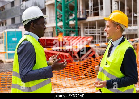 Two engineers standing on construction site and talking Stock Photo