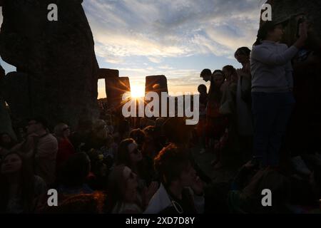 Salisbury, England, UK. 20th June, 2024. As the sun sets the sun aligns with the stones at Stonehenge during the Summer solstice celebrations. Stonehenge was built by early Britons some 4000 years ago to align with the sun on the solstices. The summer solstice marks the end of Spring and the start of Summer and is the longest day and the shortest night in the Northern Hemisphere. The event is celebrated by thousands of pagans worldwide with singing and dancing. (Credit Image: © Martin Pope/ZUMA Press Wire) EDITORIAL USAGE ONLY! Not for Commercial USAGE! Stock Photo