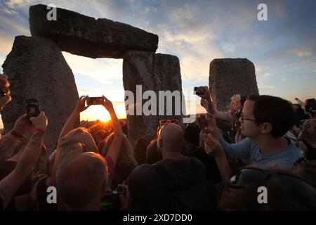 Salisbury, England, UK. 20th June, 2024. People use their phones to photograph the sun as it sets aligning with the stones at Stonehenge during the Summer solstice celebrations. Stonehenge was built by early Britons some 4000 years ago to align with the sun on the solstices. The summer solstice marks the end of Spring and the start of Summer and is the longest day and the shortest night in the Northern Hemisphere. The event is celebrated by thousands of pagans worldwide with singing and dancing. (Credit Image: © Martin Pope/ZUMA Press Wire) EDITORIAL USAGE ONLY! Not for Commercial USAGE! Stock Photo