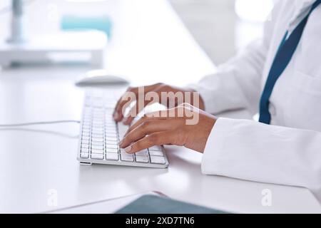 Hands, keyboard and scientist typing at desk for research, healthcare and medicine on hospital internet. Computer, person and medical professional Stock Photo