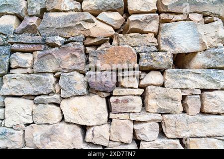 A wall made of stone with a few bricks missing Stock Photo