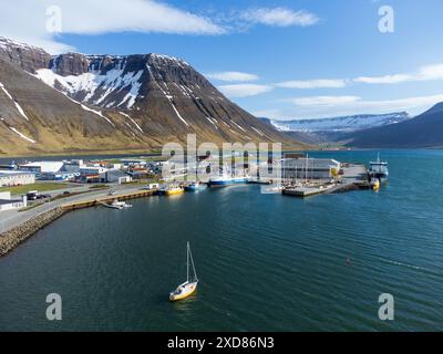 Aerial view of Isafjordur (Ísafjörður) and the harbour with sailboats, fishing boats, Iceland, colorful buildings, sea, fjord, moutains with snow. Stock Photo