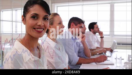 Image of statistical data processing against biracial woman smiling at office Stock Photo
