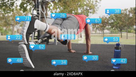 Image of social media icons with numbers, african american man with prosthetic leg doing plank Stock Photo