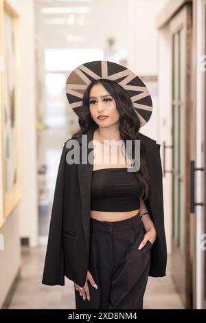 Hispanic woman walking wearing stylish clothes and wearing hat Stock Photo