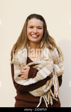 Smiling friendly woman in a plain white lab coat standing demurely with ...