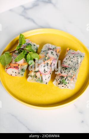 three fresh spring rolls on a yellow plate Stock Photo