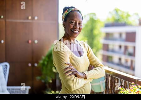 Portrait of smiling woman standing on the balcony at home Stock Photo