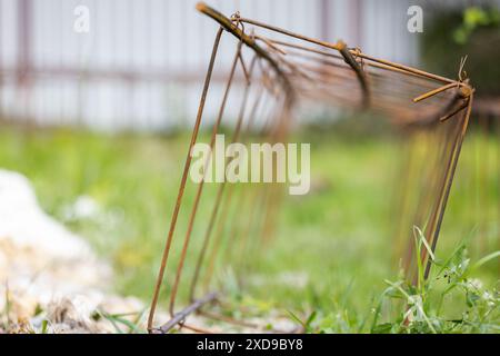 Reinforcement cage lay on green grass at construction site, abstract industrial background photo with soft selective focus Stock Photo