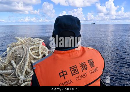 (240621) -- SANSHA, June 21, 2024 (Xinhua) -- A law enforcer of China Coast Guard is pictured on the way to Chinese fishing boats with retrieved fishing nets in China's Ren'ai Jiao and the surrounding territorial sea, June 11, 2024. Recently, in China's Ren'ai Jiao and the surrounding territorial sea, personnel from the illegally grounded Philippine navy transport ship repeatedly damaged Chinese fishermen's nets and deployed the illegally obtained fishing nets to the nearby waters of their ship to obstruct the law enforcement of China Coast Guard (CCG).  CCG law enforcers have retrieved these Stock Photo