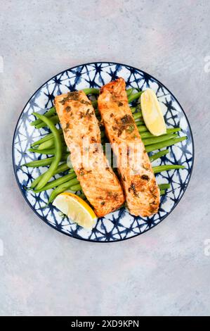Delicious baked salmon fillets garnished with bush green beans. Mediterranean food. Top view. Stock Photo