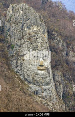 Dubova, Romania - March 14, 2024: Rock Sculpture of Decebalus Rex Dragan Fecit Last King of Dacia Colossal Face Carving in Stone Cliff Close up. Stock Photo