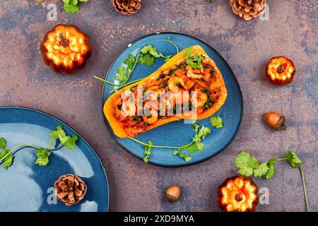 Roasted butternut squash stuffed with peppers, tomatoes and shrimp. Top view. Stock Photo