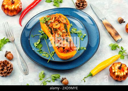 Autumn butternut squash stuffed with peppers, tomatoes and shrimp. Stock Photo