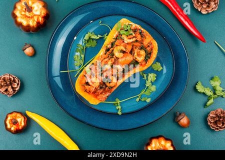Roasted autumn butternut squash or pumpkin stuffed with peppers, tomatoes and shrimp. Stock Photo