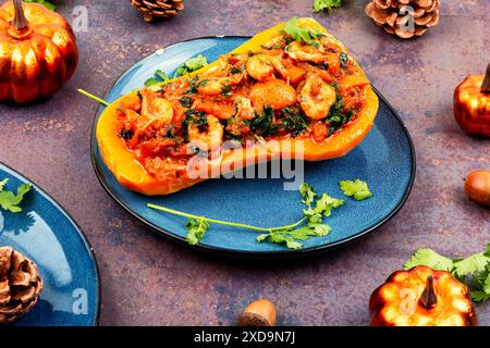 Autumn butternut squash stuffed with peppers, tomatoes and shrimp. Stock Photo