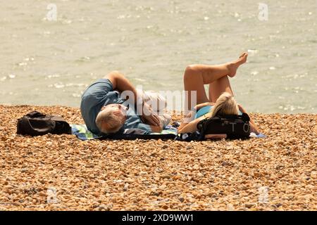 City of Brighton & Hove, East Sussex, UK. Sun seekers go down to the beach at Brighton and Hove on the first day of summer 2024. 21st June 2024. David Smith/Alamy Stock Photo