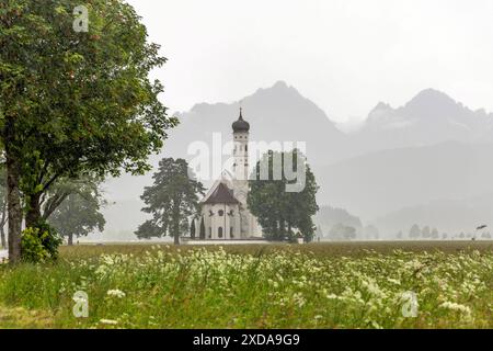 St. Coloman im Regen Bei Starkregen während eines Gewitters ist die Kirche St. Coloman vor den Bergen der Alpen im Hintergrund zu sehen., Schwangau Bayern Deutschland *** St Coloman in the rain In heavy rain during a thunderstorm, the church of St Coloman can be seen in front of the mountains of the Alps in the background, Schwangau Bavaria Germany Stock Photo