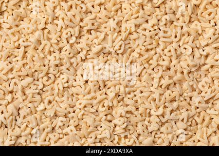 Heap of uncooked alphabets pasta isolated on white background close up Stock Photo