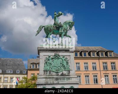 Equestrian statue on a pedestal with coat of arms, surrounded by historic buildings and blue sky, luxembourg Stock Photo