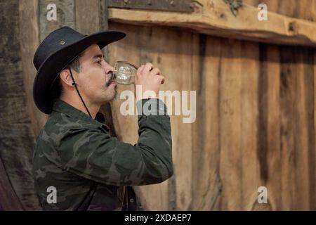 latin man with cowboy hat in profile doing a wine tasting at a wine tasting on an excursion to a winery in Cafayate, Salta, Argentina. Stock Photo