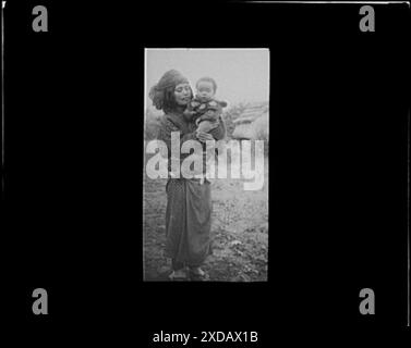 Ainu woman holding a child standing outside. Genthe photograph collection. Stock Photo