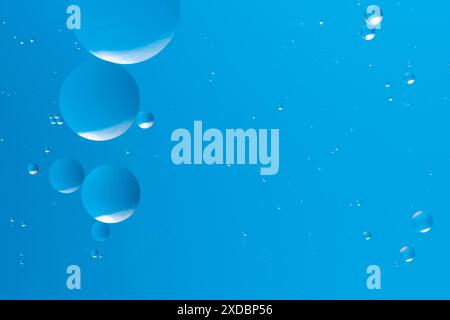 Blue bubbles float in a gradient of light blue, forming soothing and minimalistic abstract pattern serene background Stock Photo