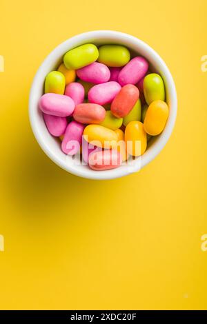 Colorful hard mint Candies in a bowl on yellow background. Top view. Stock Photo