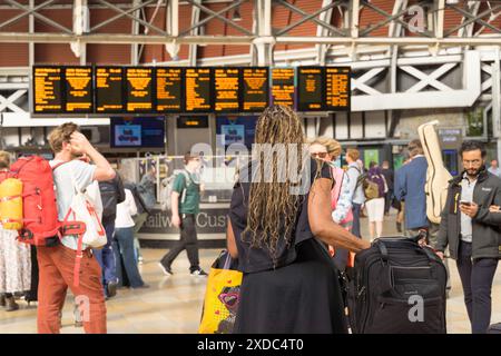 London, UK, 121st June 2024. UK Weather: travellers with backpacks checking the train departure LED boards for their next trains and departure time at London train terminal, starting their mini-heatwave weekend, London England.  Credit: Xiu Bao/Alamy Live News Stock Photo