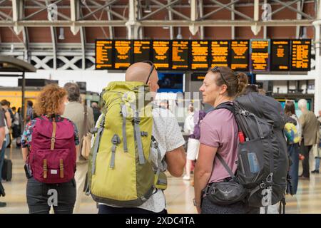 London, UK, 121st June 2024. UK Weather: travellers with backpacks checking the train departure LED boards for their next trains and departure time at London train terminal, starting their mini-heatwave weekend, London England.  Credit: Xiu Bao/Alamy Live News Stock Photo