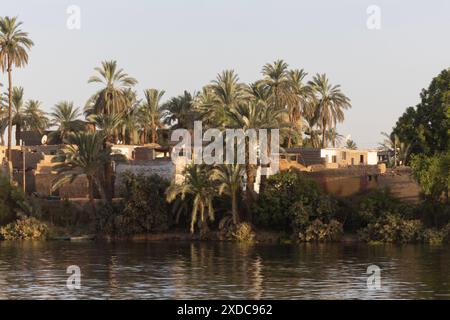 An Egyptian mudbrick village clusteredalong the river Nile between Esna and El-Kab with graffiti in Arabic script clearly visible on a white wall . Stock Photo