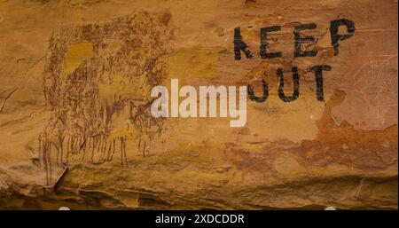 “KEEP OUT.”  Ancient pictograph, otherworldly, mysterious and unknown, defaced by a Utah rancher, warning away visitors in the 1950s. Stock Photo