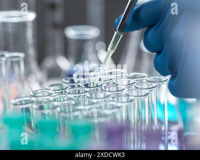 Scientist extracting samples using a pipette for analytical testing in the lab. Stock Photo