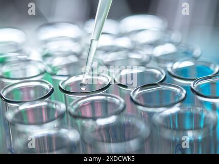 Scientist extracting samples using a pipette for analytical testing in the lab. Stock Photo
