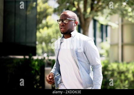 Efficient African American Courier Navigating Busy City Streets for Corporate Success in Fast-Paced Office Environment Stock Photo