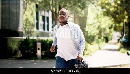 Fast-paced African businessman navigating city streets, young analyst juggling tasks in office, real estate agent finalizing deals. Multitasking profe Stock Photo