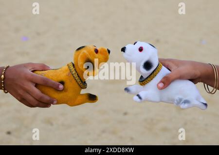 Two hands hold plush dog toys, mimicking interaction. Golden retriever and Dalmatian toys meet playfully. Stock Photo