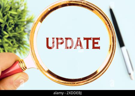 Business concept. UPDATE Word written through a magnifying glass on a light background Stock Photo