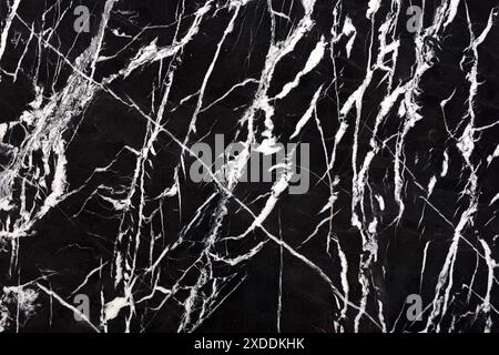 High-contrast black and white marble texture with dynamic and intricate vein patterns. The sharp lines and stark contrast between the black background Stock Photo