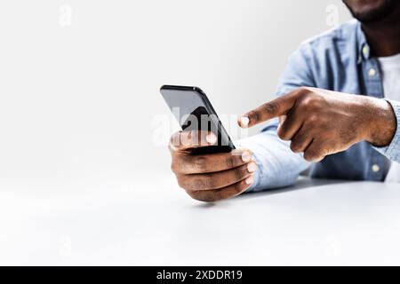 Innovation at Work: Young African American Executive Engaged in Virtual Meeting Using Business Apps on Smartphone in Corporate Office. Stock Photo