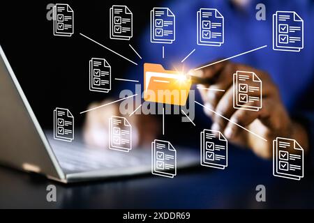 Young African-American businessman using virtual reality system to manage financial files on laptop for his cybersecurity company. Stock Photo