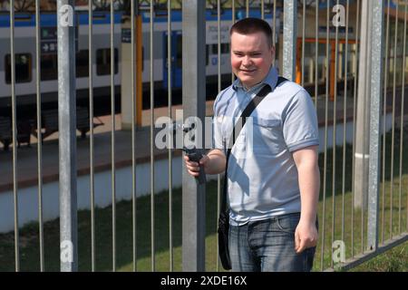 A young man videotaping on a smartphone. Uses gimbal to get smooth shots. Stock Photo