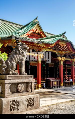 Main hall called 'honden' and statue of a komainu, in Nezu Jinja, a Shinto shrine established in Tokugawa era and located in the Bunkyō ward of Tokyo Stock Photo