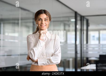 Mature smiling business woman standing in office looking at camera, portrait. Stock Photo