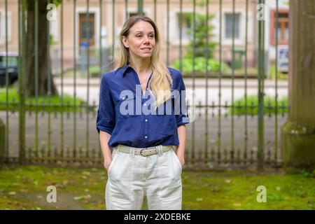 A woman wearing a blue shirt and white pants enjoys an outdoor stroll. Stock Photo