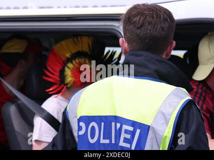 Aachen, Germany. 22nd June, 2024. A police officer waves a vehicle into ...