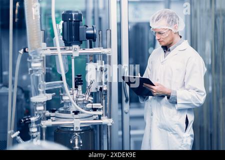 Scientist Medical Factory Staff Working in Science Lab. Medicine factory Technician Employee Check Care Products Quality in Sterilize Room Taking Note Stock Photo
