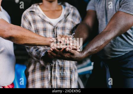 Closeup of diverse people workers joining their hands together for unity group teamwork. Stock Photo